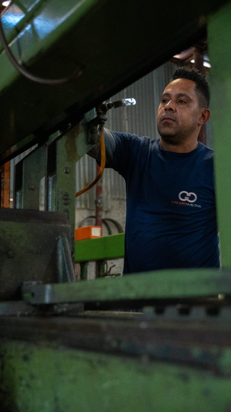 Colaborador da Galera Metais operando máquina no galpão